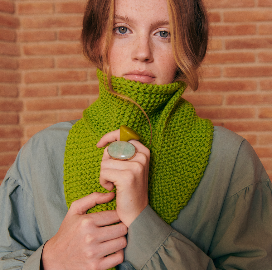 Mujer con cuello tejido en lana verde lima, hecho con el kit de tejer de Boboli by Me.