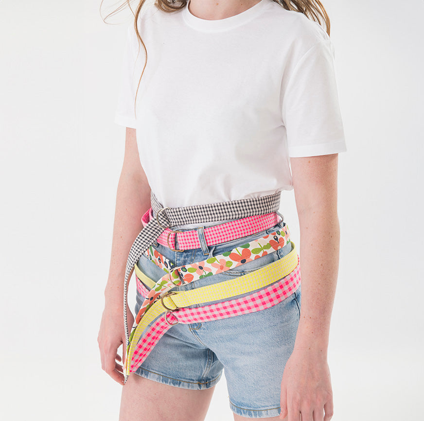 Mujer con cinturones de distintos estampados y colores, hechos con el kit de costura para accesorios de Boboli by Me.